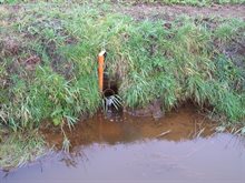 de rode kleur van het water duidt op ijzer in de sloot